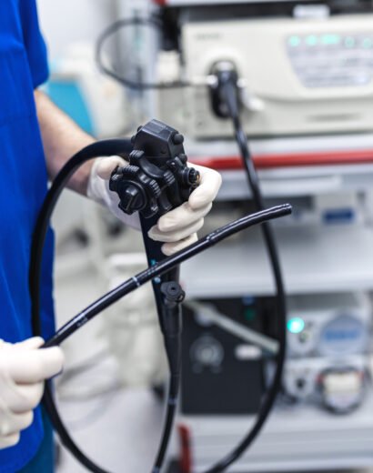 Doctor proctologist holding endoscope during colonoscopy. Probe colonoscope. Doctor gastroenterologist with probe to perform gastroscopy and colonoscopy